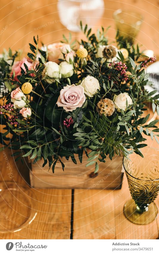 Blumen und Pflanzenzweige auf einem Kasten, der einen Holztisch schmückt Haufen Blatt Blumenstrauß Blütenblatt Konzept Glas frisch Blütezeit Innenbereich