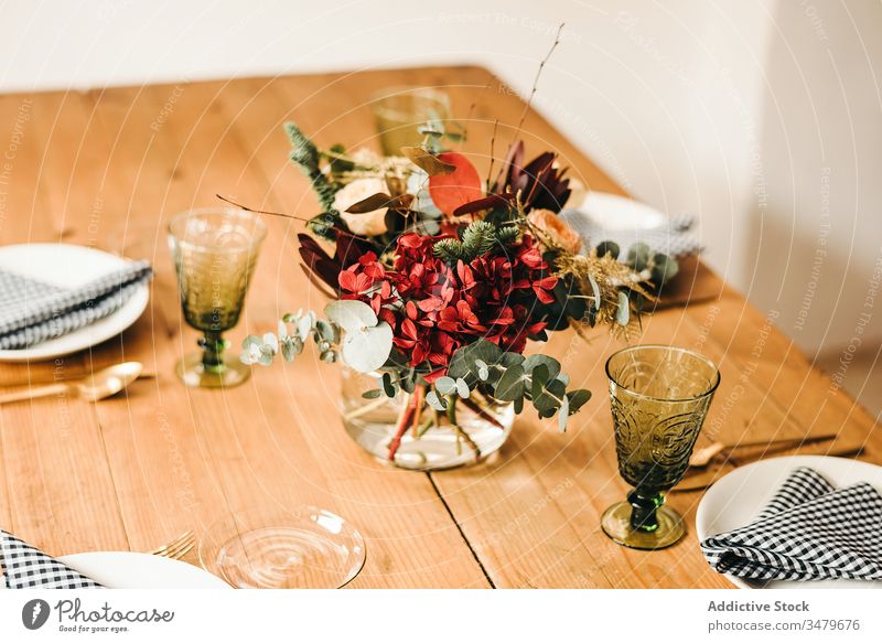 Blumen und Pflanzenzweige auf einer Vase, die einen Holztisch schmückt Haufen Blatt Blumenstrauß Wasser Blütenblatt Konzept Glas frisch Blütezeit Innenbereich