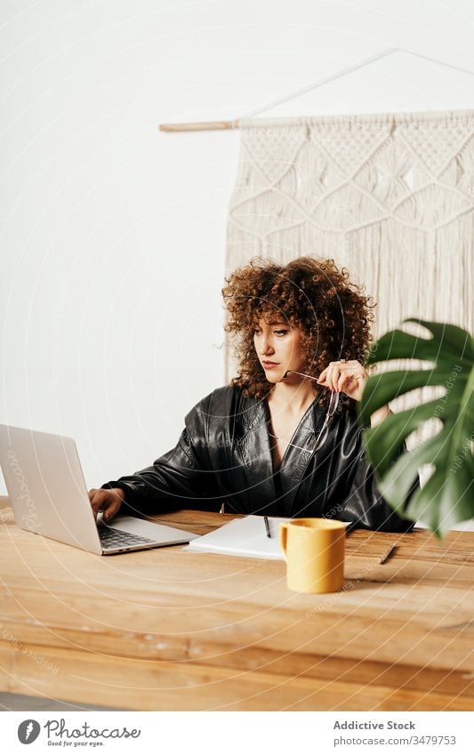 Im Büro arbeitende Retro-Geschäftsfrau Arbeit Laptop Daten lesen retro Tisch Leder sitzen Projekt Business Frau altehrwürdig krause Haare Job Apparatur Jacke