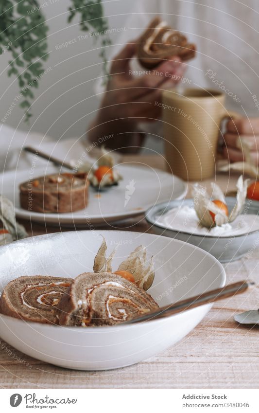 Gebackener Brötchenkuchen mit Physalisblüten rollen süß Kuchen Dessert Sahne selbstgemacht dienen Scheibe gebacken Lebensmittel lecker Teller geschmackvoll