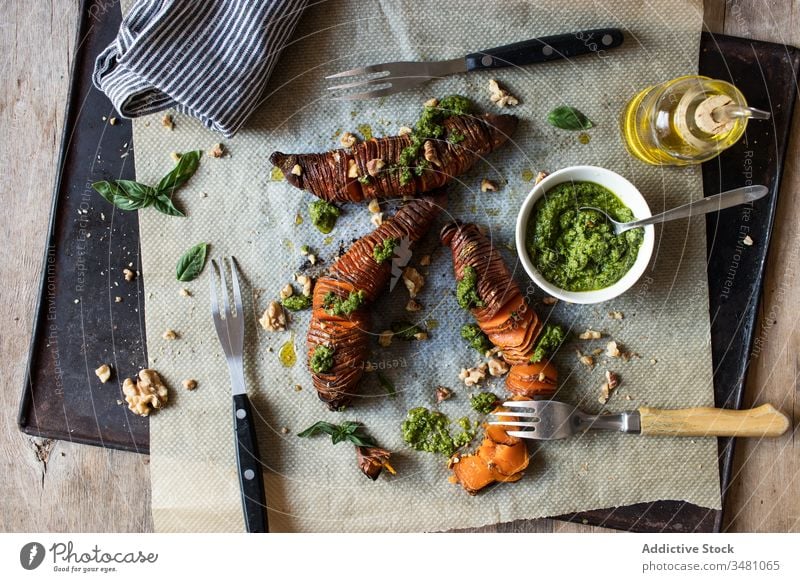 Süsskartoffel mit Pestosauce Maniok Süßkartoffel Speise Braten Tisch Tablett Papier Gabel Erdöl schäbig Mahlzeit lecker Lebensmittel geschmackvoll Küche