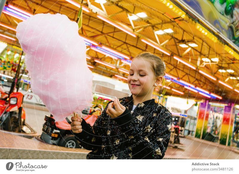 Mädchen isst Zuckerwatte auf Kirmes Jahrmarkt Lächeln Lichter Großstadt Fairness Entertainment Kind Glück urban süß Spaß erfreut Leckerbissen Lifestyle heiter