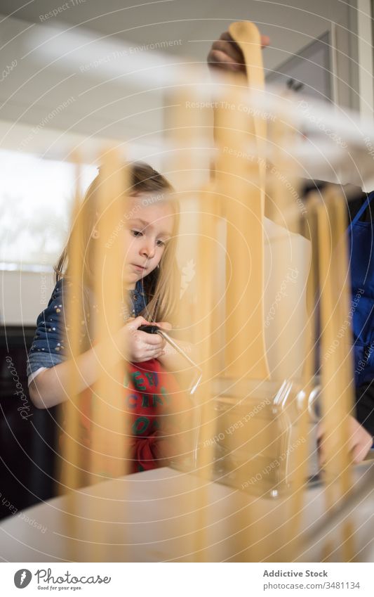 Kleines Mädchen macht in der Küche Nudeln Kind Spätzle machen trocknen hängen Maschine vorbereiten Lebensmittel lernen Schürze Frau ernst Koch Ablage