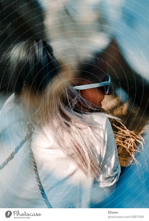 Junge Frau chillt am See frau mädchen entspannung erholung see natur landschaft unschärfe effekt sonnebrille zufriedenheit t-shirt blond lange haare sommer