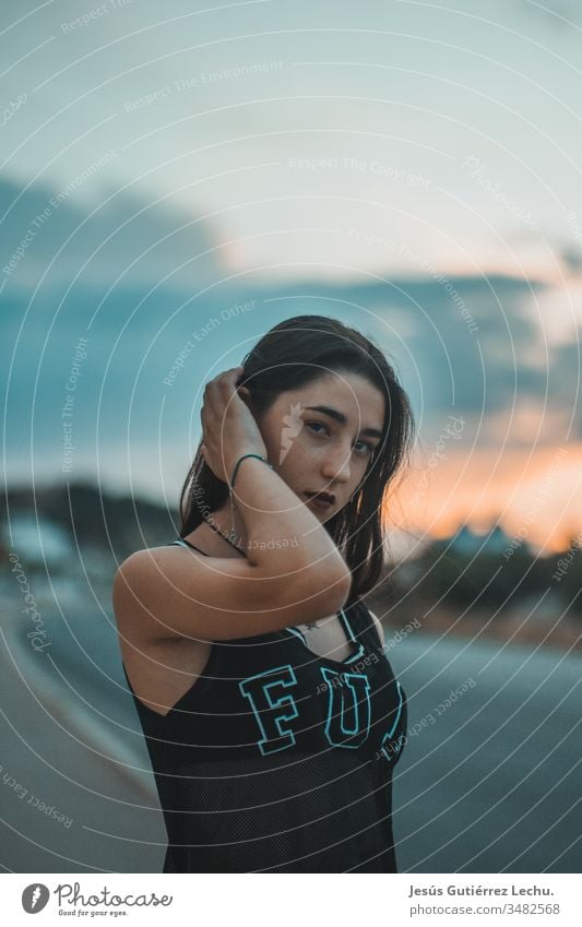 junges Mädchen mit ernstem Blick mit einem schönen Sonnenuntergang im Hintergrund Leben Spanien Farbfoto Oberkörper Vorderansicht Hipster Menschen jugendlich