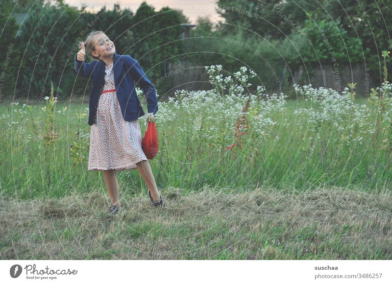 mädchen steht in einer blumenwiese in der natur und hält den daumen nach oben Kind Mädchen Wiese Natur Blumenwiese Feld Acker auf dem Land Landschaft Sommer