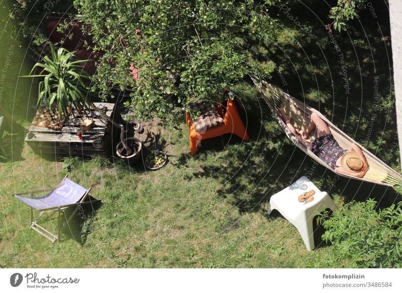 Blick von oben auf Frau in Hängematte im Garten Mittagsschlaf Halbschlaf chillen sich wohl fühlen Lebensfreude Erholung Zufriedenheit liegen ruhig Pause