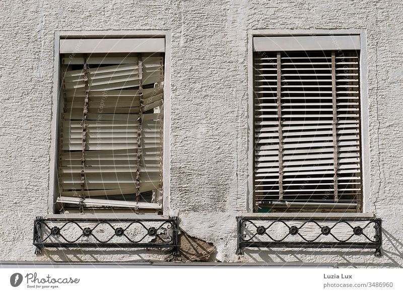 Fenster mit kaputten Rollos, Hauswand, Schattenspiel Jalousien alt rauhputz Sonne Sonnenlicht Sonne Stadt urban trist vergänglich schief weiß