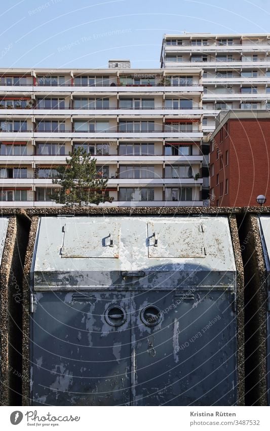 müllcontainer und wohnblock mülltonne mülleimer müllentsorgung mehrfamilienhaus mehrfamilienhäuser wohnsiedlung hochhaus hochhäuser gebäude fassade balkone