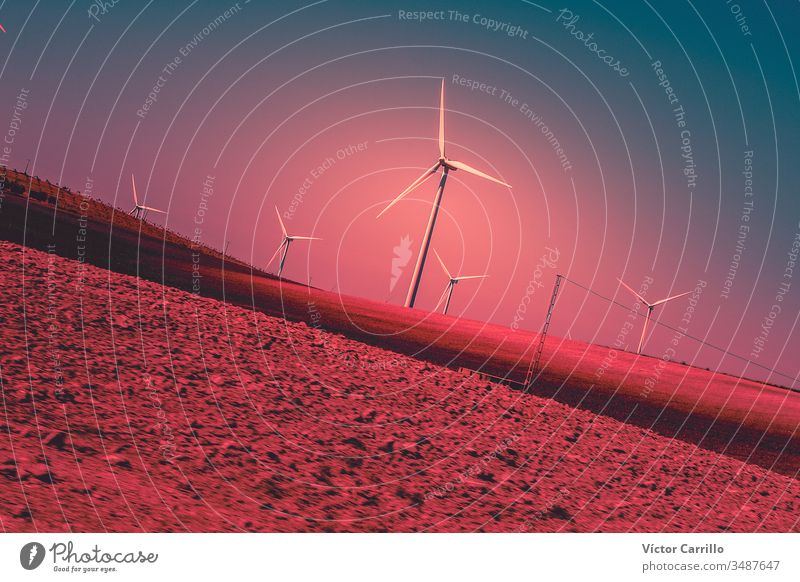 Eine elektrische Windmühlenturbine in einem farbenfrohen Sonnenuntergang und Landschaft Energie Kraft Turbine Elektrizität Himmel Umwelt Bauernhof alternativ