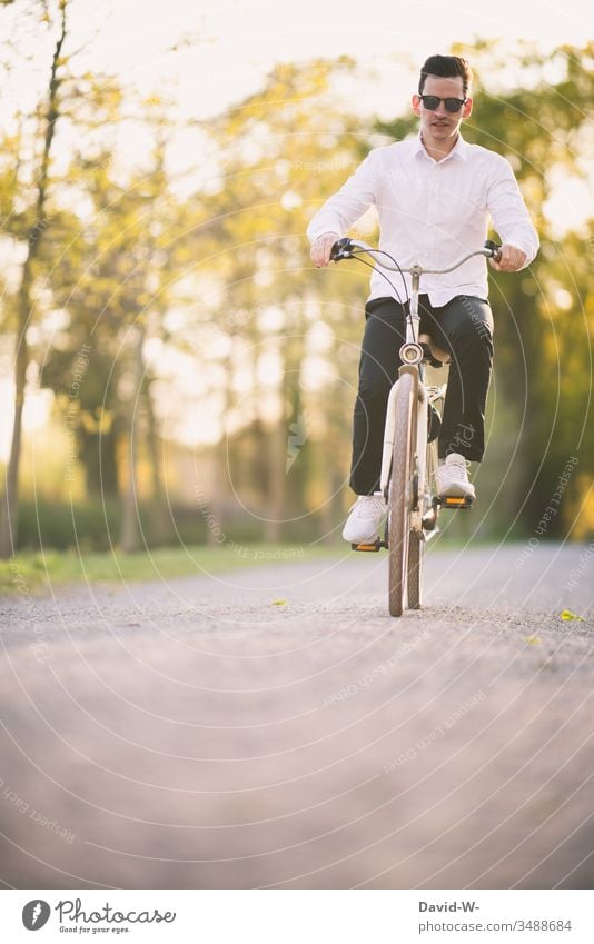 Junger Mann unterwegs mit dem Rad Fahrrad Verkehr Straße Fahrradweg fahren Verkehrsmittel Verkehrswege Wege & Pfade Fahrradfahren Bewegung Straßenverkehr