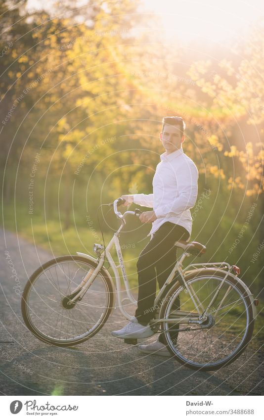 Mann fährt mit dem Fahrrad durch die Natur und macht eine Fahrradtour Fahrradfahren Sonnenlicht Schönes Wetter spass Freude enstpannung Naturliebe Ruhe