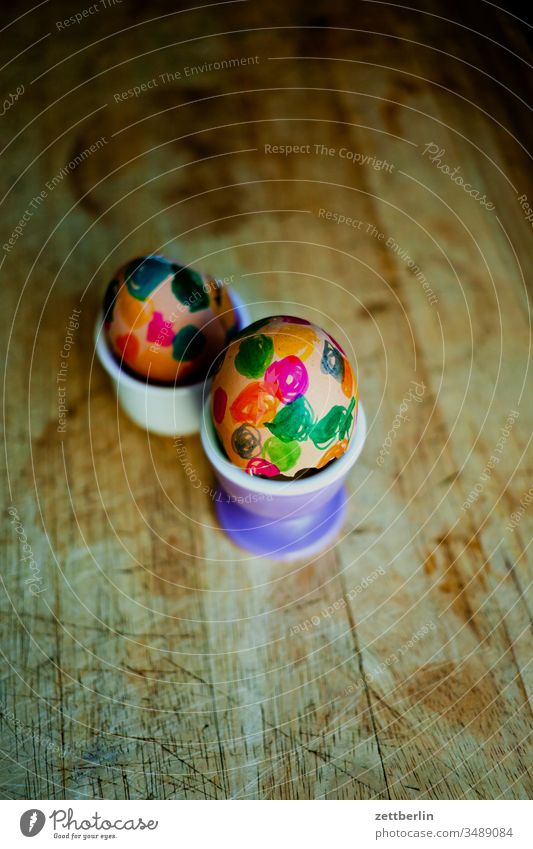 Zwei Ostereier eierbecher frühstück hühnerei osterei osterfest ostern bunt farbe holz brett holzbrett frühstücksbrett eierschale cholesterin punkt farbkringel