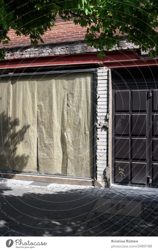 verlassenes ladenlokal geschlossen zu geschäft schaufenster abgeklebt zugeklebt fassade aufgabe aufgeben bankrott konkurs pleite geschäftsaufgabe leer business