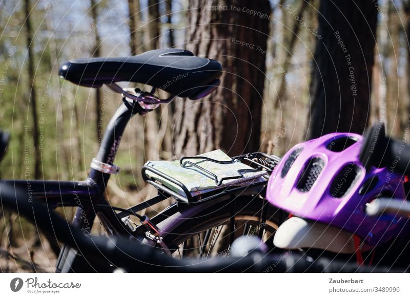 Sattel eines Fahrrads mit Karte und Fahrradhelm bei einer Radtour im Wald Landkarte Gepäckträger Bäume lila Fahrradsattel grün Freizeit & Hobby