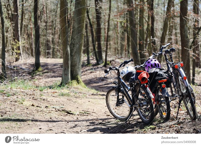 Fahrräder einer Familie bei einer Radtour auf einem Waldweg Fahrrad Fahrradhelm Kinderfahrrad Fahrradfahren Fahrradtour Sonne