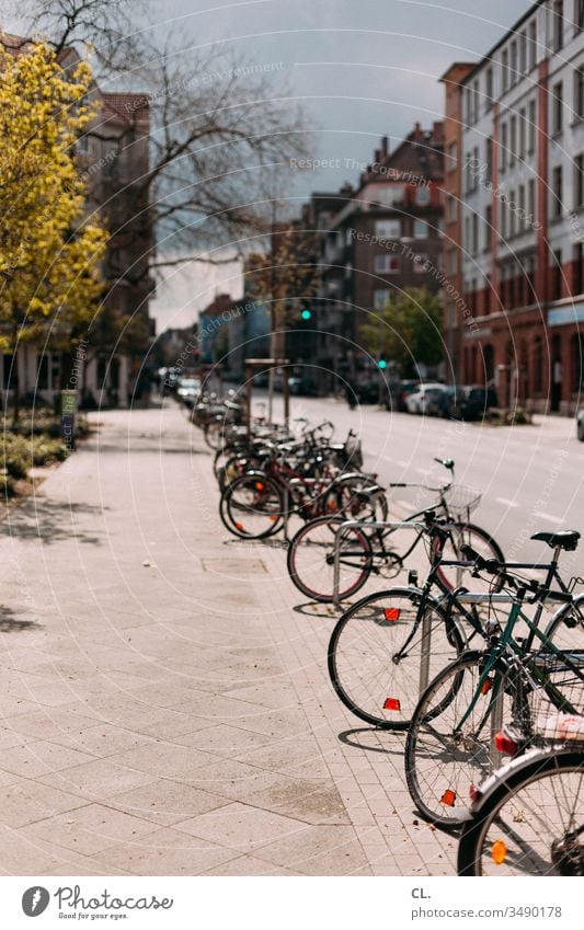 parkende fahrräder in der stadt Fahrrad Straße Verkehrswege Verkehrsmittel Straßenverkehr Fahrräder Parkplatz gehweg Stadt Mobilität Häuser Fahrradfahren