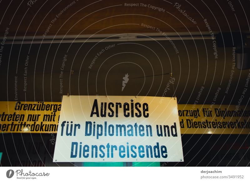 Ein Großes in weiß gehaltenes  Hinweis - Schild / Ausreise für Diplomaten und Diestreisende / Grenzübergang DDR - Deutschland Berlin. schild Architektur modern