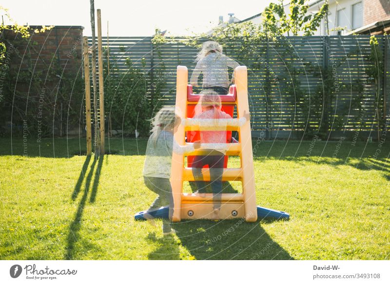 Mädchen spielt im Garten und rutsch die Rutsche runter Kind Spielen rutscht rutschen Kindheit Kleinkind Fröhlichkeit Sommer fröhlich Glück Mensch niedlich