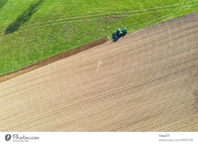 Traktor gräbt ein Feld von oben Traktor von oben historischer Traktor grüner Traktor Traktor auf einem Feld landwirtschaftlich Landwirtschaftlicher Weg