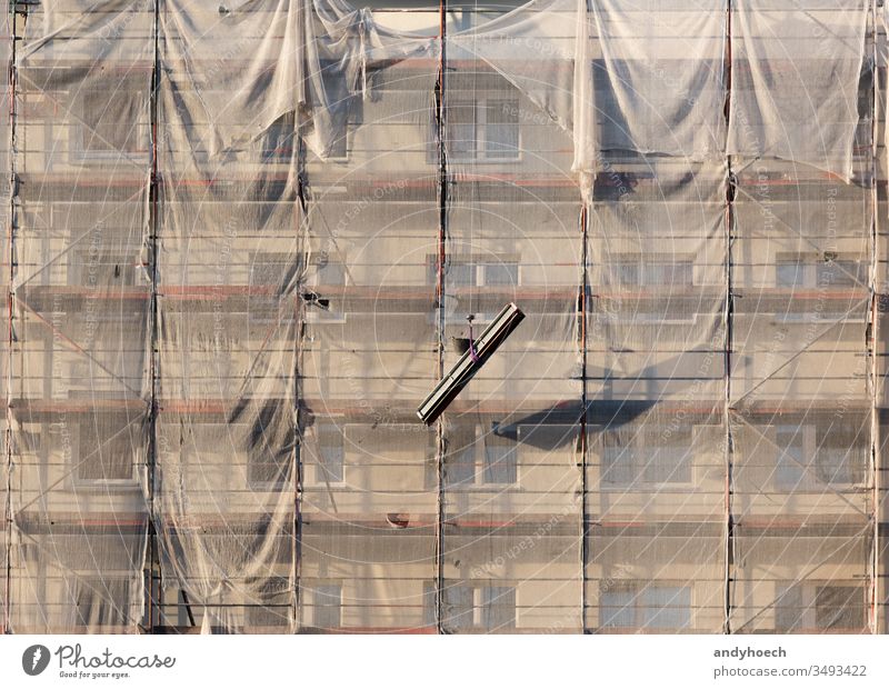 Die Gerüstteile werden mit der Umlenkrolle abgesenkt Wohnhaus Architektur bei der Arbeit Hintergrund Gebäude Gebäudeaußenseite Bauindustrie gebaute Struktur