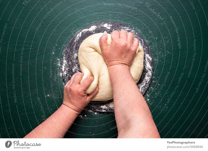 Kneten von Pizzateig auf grünem Tisch. Teig kneten zu Hause obere Ansicht backen Bäckerei Brot backen farbenfroh Essen zubereiten Teigwaren flache Verlegung