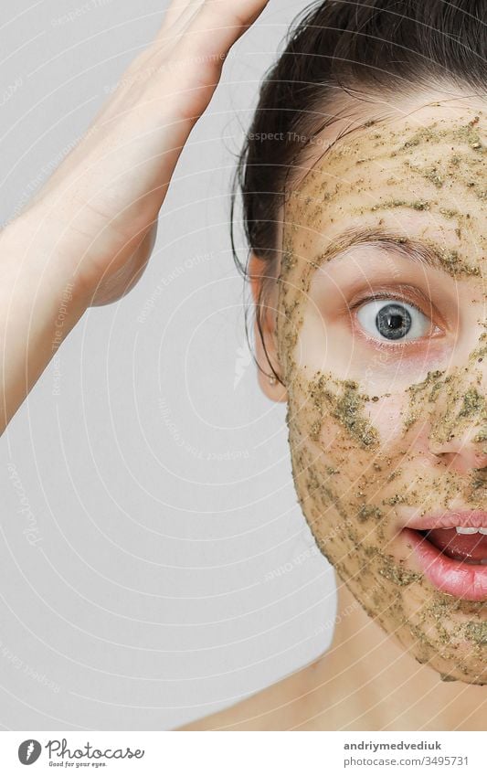 Hautpflege. Cosmetic Day. junges Mädchen in häuslicher Form, die Haare mit den Händen oben zusammengerafft. Mit ökologischer, pflanzlicher, natürlicher Maske, grün im Gesicht. Vorderansicht.