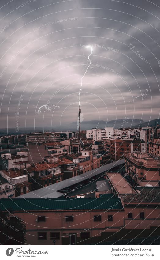 Blitzschlag in eine Antenne mit einer Stadt im Hintergrund, mitten in einem Sturm Hafengebiet Wasser Ansicht Victoria Peak Dämmerung urban Hafen von Victoria