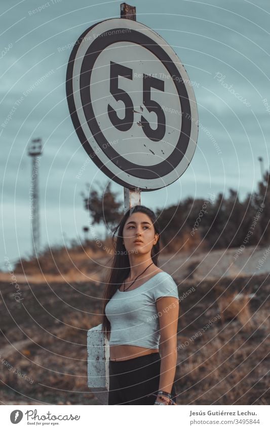 junges Modell, das ein weißes Oberteil mit einem Poster dahinter trägt Stil Frau Farbfoto schön Junge Frau Farbe Mensch Porträt Phantasie Mysterium Licht