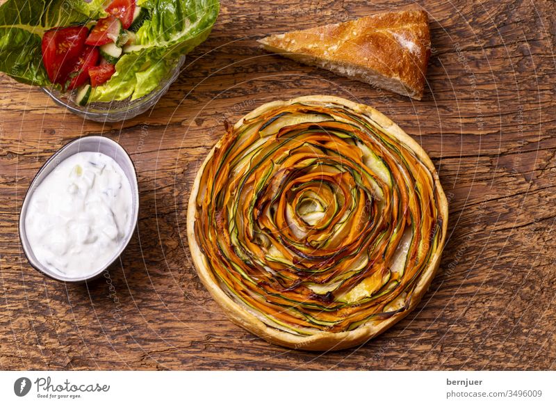 Kuchen mit Karotten und Zucchini auf Holz Zucchinikuchen Muster Aufsicht Planke rustikal rund herzhaft Gourmet zubereitet gekocht gesund Gebäck Gartengemüse