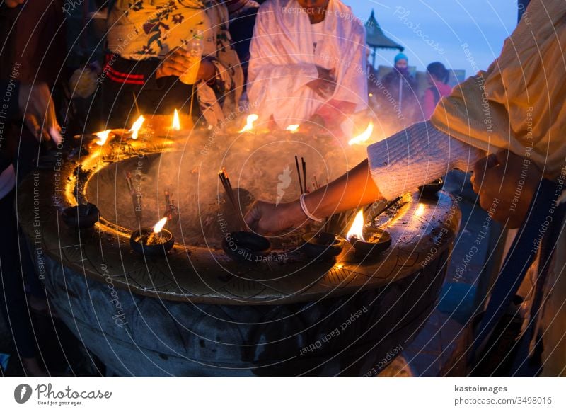 Buddhistische Frau opfert Weihrauch und Kerzen, die auf dem buddhistischen Klosteraltar auf dem Gipfel des Adam's Peak in Sri Lanka brennen. Tempel Altar adam