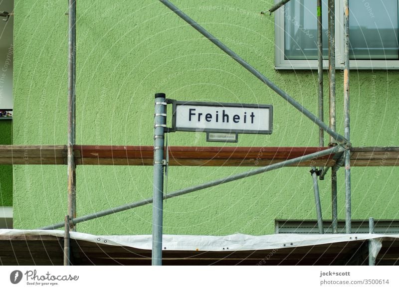 Freiheit erfordert umfassende Renovierung Straßennamenschild Fassade Wegweiser Orientierung spandau Verkehrswege Metallstangen Gerüst Renovieren Sanieren