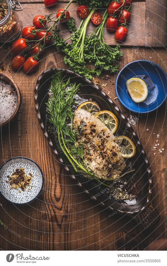 Gebackenes gebratenes Fischfilet in Backform mit Dill und Zitrone auf Holzuntergrund, Ansicht von oben. Konzept der Hausmannskost. Meeresfrüchte, Low Carb und Diätnahrung