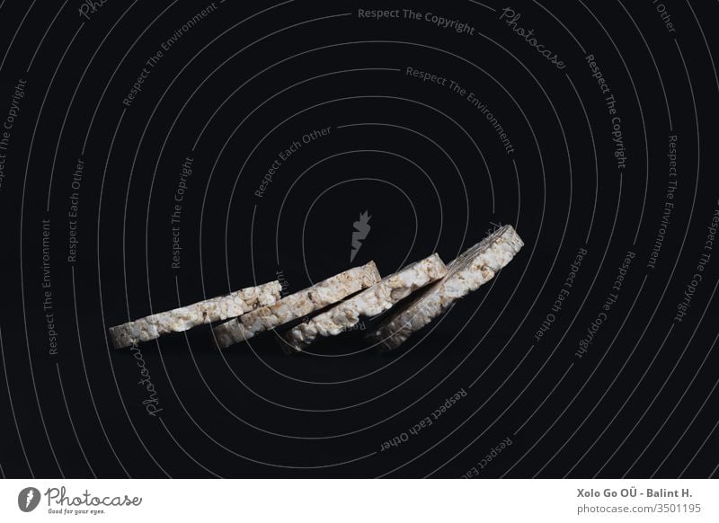 Puffreisscheiben, angeordnet wie eine Dominokette auf schwarzem Hintergrund gepufft Reis glutenfrei Gesunder Lebensstil gesundes Leben Gesunde Ernährung