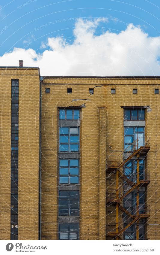 Altes Industriegebäude von außen mit verrosteter Treppe Verlassen antik Appartement architektonisch Architektur Hintergrund Blauer Himmel Baustein Gebäude