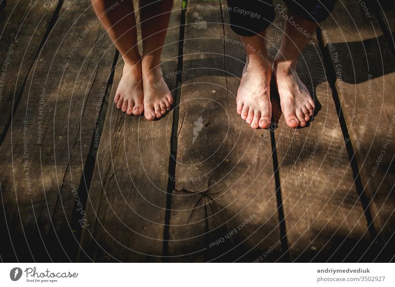 Draufsicht nackte Füße eines männlichen und weiblichen Paares auf einer Holzbrücke stehend zwei Zusammensein Beine Lifestyle Hintergrund schön Brücke Tag Mode