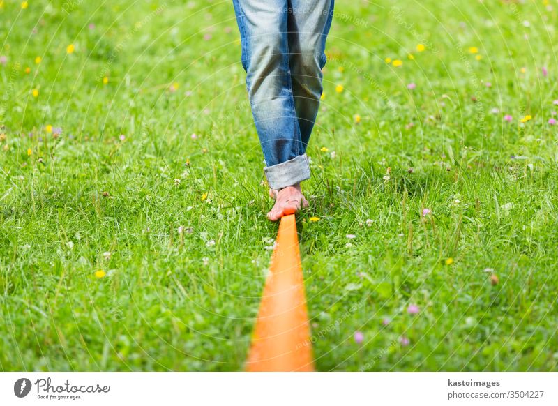 Slackline im Stadtpark. Schlaffleitung Aktivität Sport schlaff Linie Gleichgewicht Drahtseil jung Person Seil Fitness Rücken Natur Konzentration männlich passen