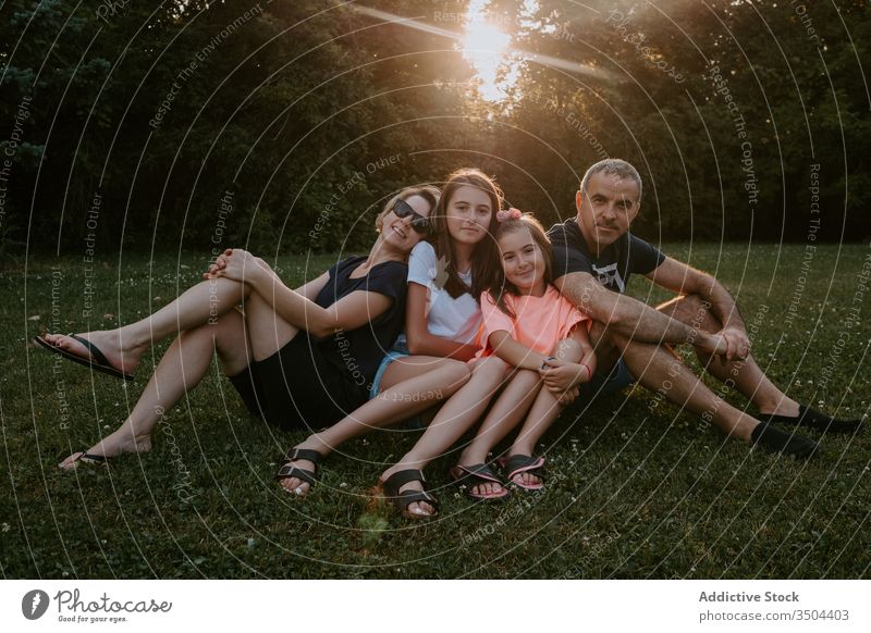 Glückliche Familie ruht sich auf der grünen Wiese aus Zusammensein Natur ruhen sich[Akk] entspannen sitzen Park Wald Landschaft Sommer Lächeln aktiv lässig Gras