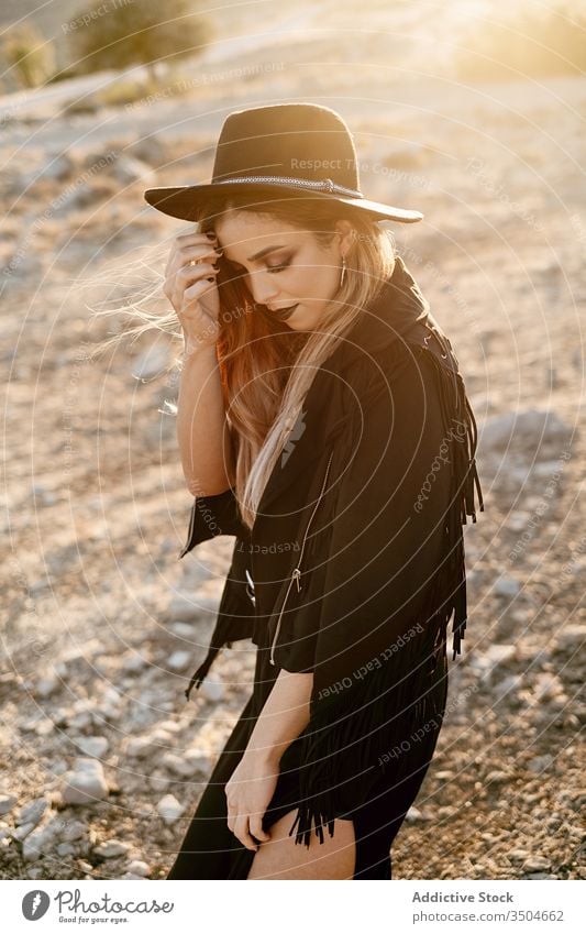 Stilvolle Frau steht auf Fels in der Landschaft Stein Sonnenuntergang Hut Spaziergang Outfit Schleim Model schwarz trendy Natur Felsen Felsbrocken Abend