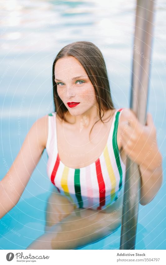 Nahaufnahme eines brünetten Mädchens mit langen Haaren auf einer Treppe im Schwimmbad Wasser Pool blau Freizeit Teenager jung Frau Person Sommer Spaß Menschen