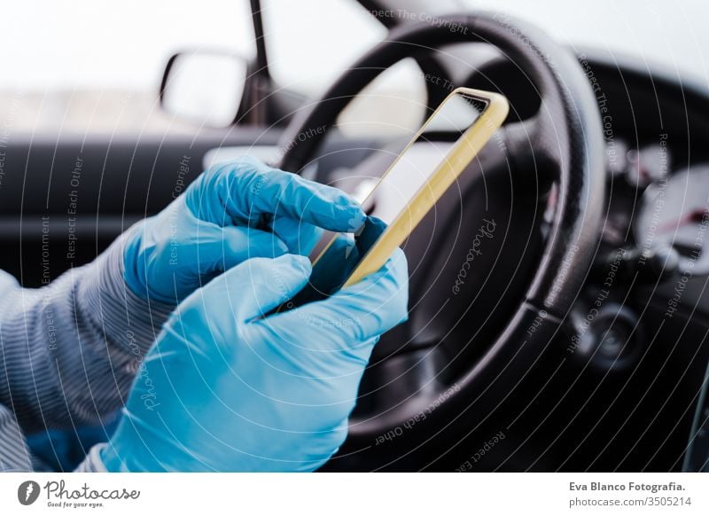 mann mit handy in einem auto mit schutzmaske und handschuhen während einer coronacirus-pandemie covid-19 Mann fahren PKW Schutzmaske Handy Schutzhandschuhe