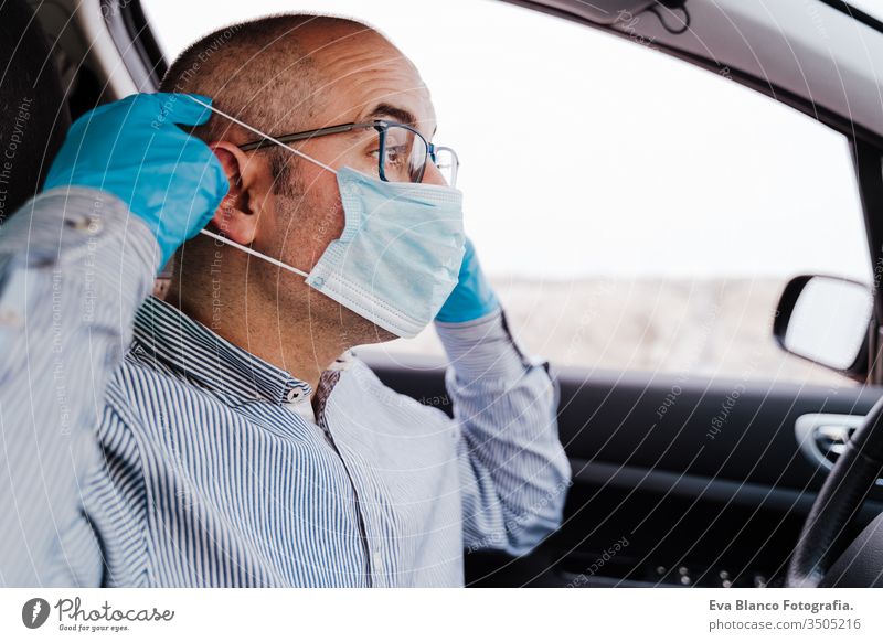 mann im auto mit schutzmaske und handschuhen während der coronacirus-pandemie covid-19 Mann fahren PKW Schutzmaske Coronavirus Pandemie Schutzhandschuhe Virus