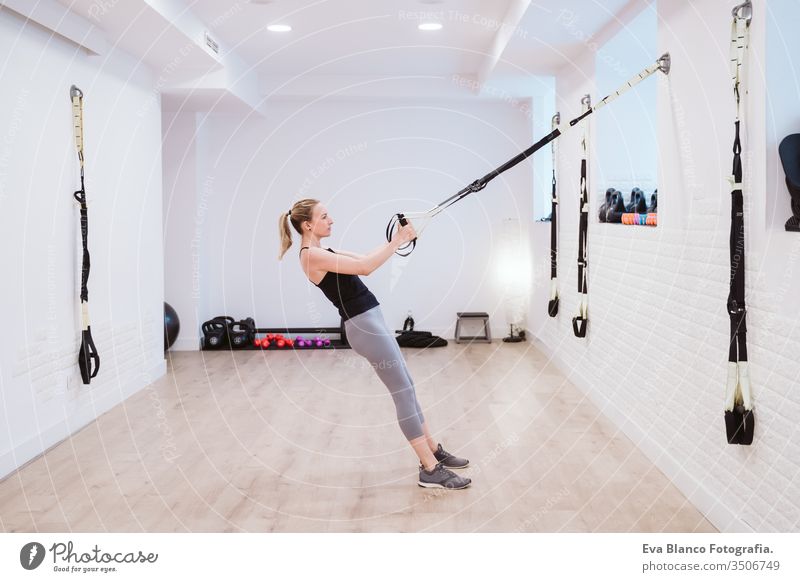 junge Frau, die im Fitnessstudio mit Trx Sport treibt. Gesunder Lebensstil Hanteln Frauen Freunde Gesundheit Lifestyle im Innenbereich Training schwer Pflege