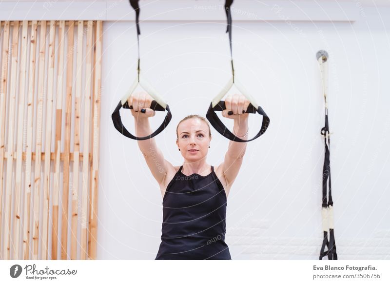 junge Frau, die im Fitnessstudio mit Trx Sport treibt. Gesunder Lebensstil Hanteln Frauen Freunde Gesundheit Lifestyle im Innenbereich Training schwer Pflege