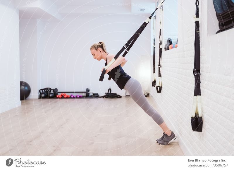 junge Frau, die im Fitnessstudio mit Trx Sport treibt. Gesunder Lebensstil Hanteln Frauen Freunde Gesundheit Lifestyle im Innenbereich Training schwer Pflege