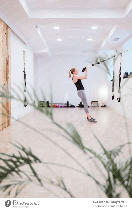 junge Frau, die im Fitnessstudio mit Trx Sport treibt. Gesunder Lebensstil Hanteln Frauen Freunde Gesundheit Lifestyle im Innenbereich Training schwer Pflege