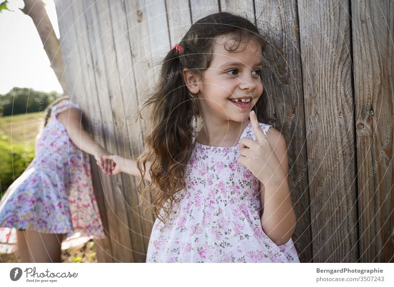 Two sisters play games playtime sommer sonne happy smiley zehen verstecken holz child Children