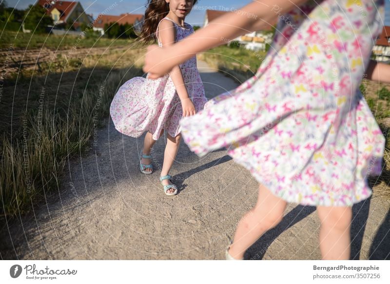 Two sisters play games Außenaufnahme Natur Tag sonne kleid girl summer playtime