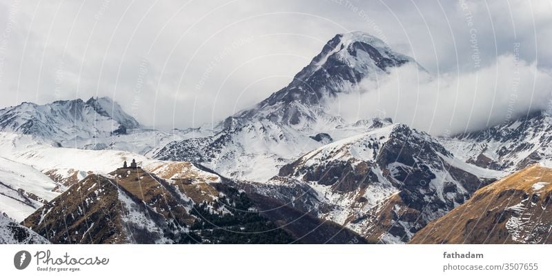 Schöne Winterlandschaft der Dreifaltigkeitskirche von Gergeti mit dem Kazbegi-Berg im Hintergrund in Georgien kazbegi tiflis Berge u. Gebirge Landschaft Kirche