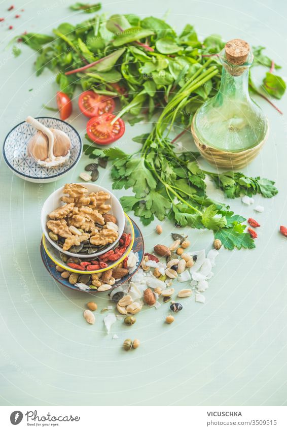 Gesunde Zutaten zur Salatherstellung. Frische Küchenkräuter. Nüsse als Belag. Olivenöle. Salatdressing . Konzept für Diät oder vegetarische Ernährung.